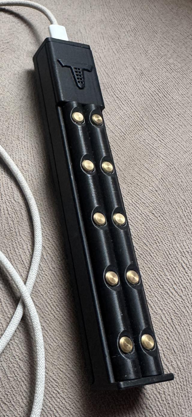 Photograph of a Tulum MIDI Controller production unit with its USB-C cable.